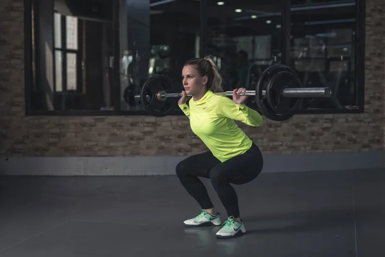 woman-doing-weighted-squats-in-gym